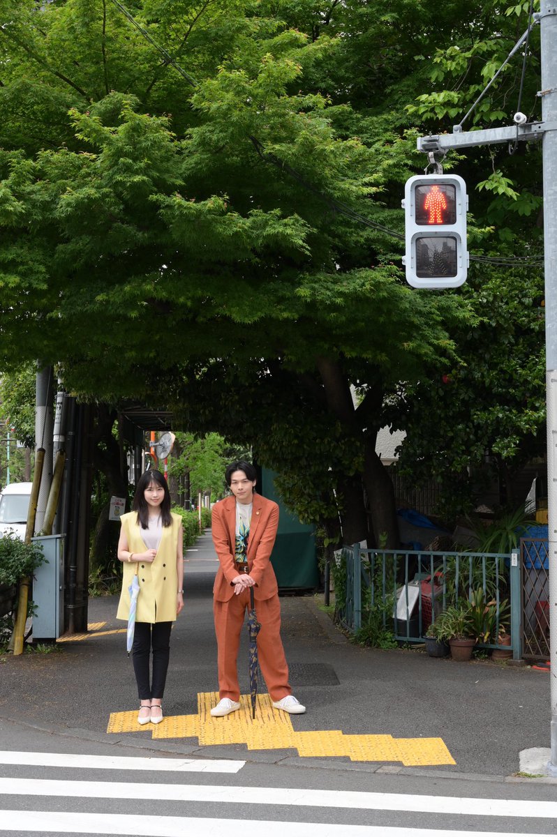 河北麻友子の私服 ドラマ 石子と羽男 より 赤信号の横断歩道で中村倫也さんとたたずむ投稿です 薄いイエローのおおきなベストを着用されています 芸能人の私服 衣装まとめ Woomy